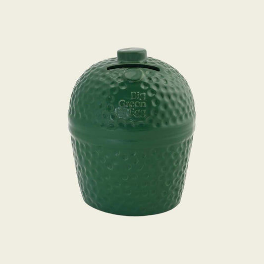 De keramische spaarpot van Big Green Egg met aan de bovenkant de sleuf waar het geld ingestopt kan worden. Onder de sleuf staat het Big Green Egg logo. De spaarpot is zelfs voorzien van de karakteristieke deukjes die de originele Big Green Egg ook heeft.