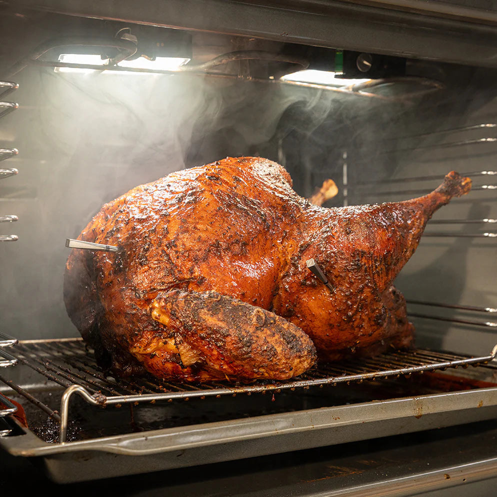 Een heerlijk, bruinkrokante kalkoen in de oven waar 2 probes van de Meater ingestoken zijn.