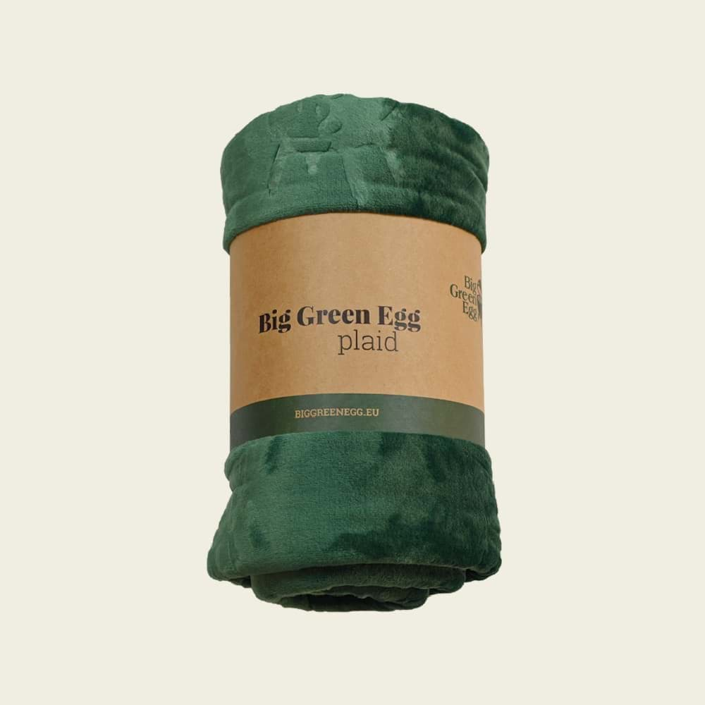 De fleecedeken is opgerold en voorzien van een bruine wikkel. Het wikkel heeft het logo van Big Green Egg en de tekst 'Big Green Egg plaid'.